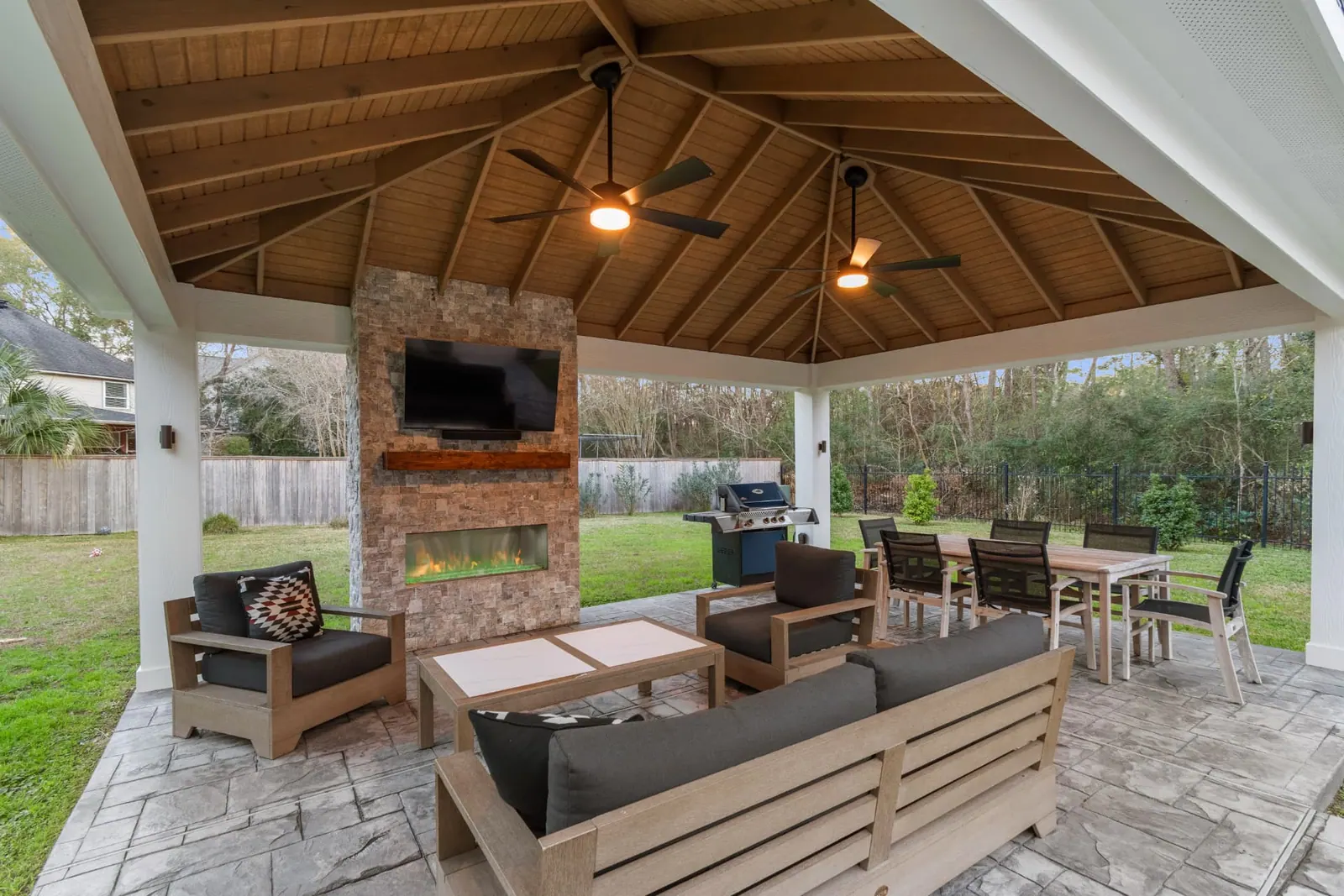Freestanding pavilion with stone fireplace, TV wall and vaulted cedar ceiling