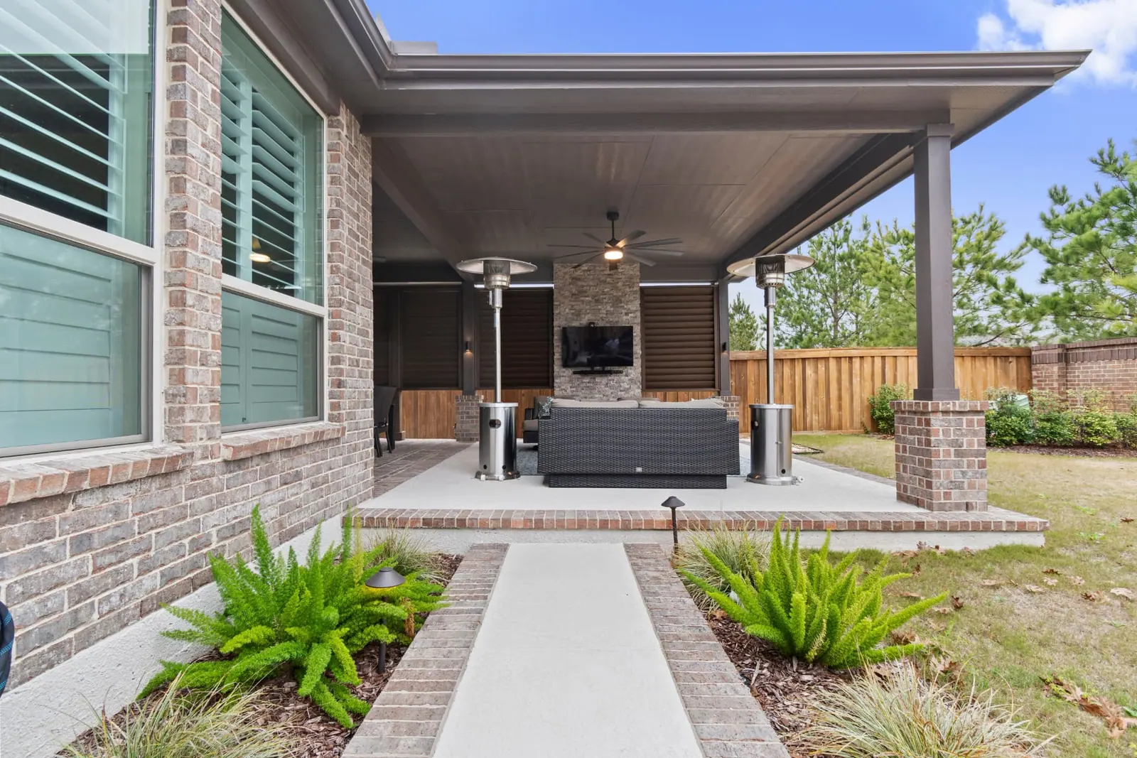 Exterior view of attached patio cover with brick columns and landscaped walkway