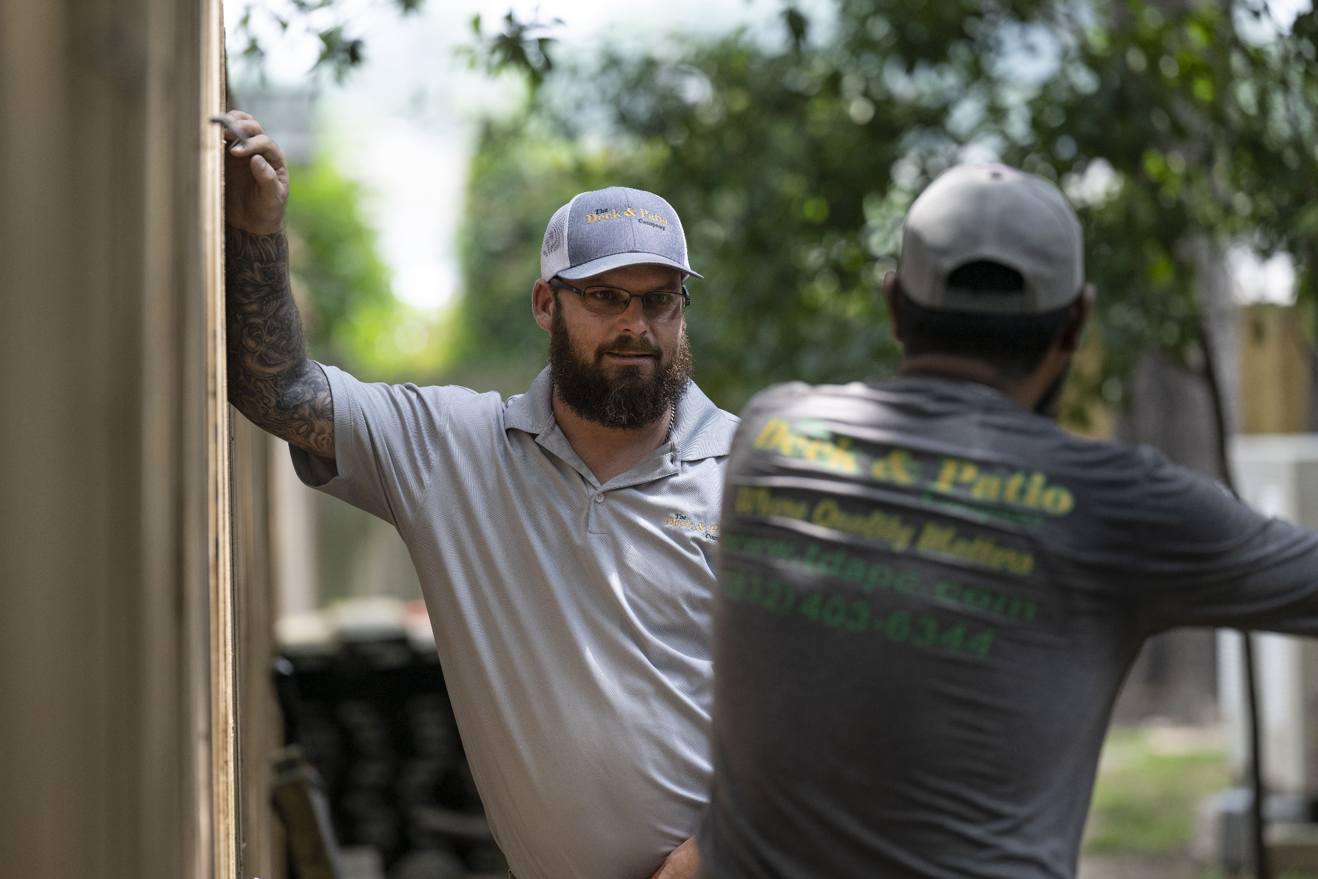 Deck & Patio Company project manager consulting with a team member on site