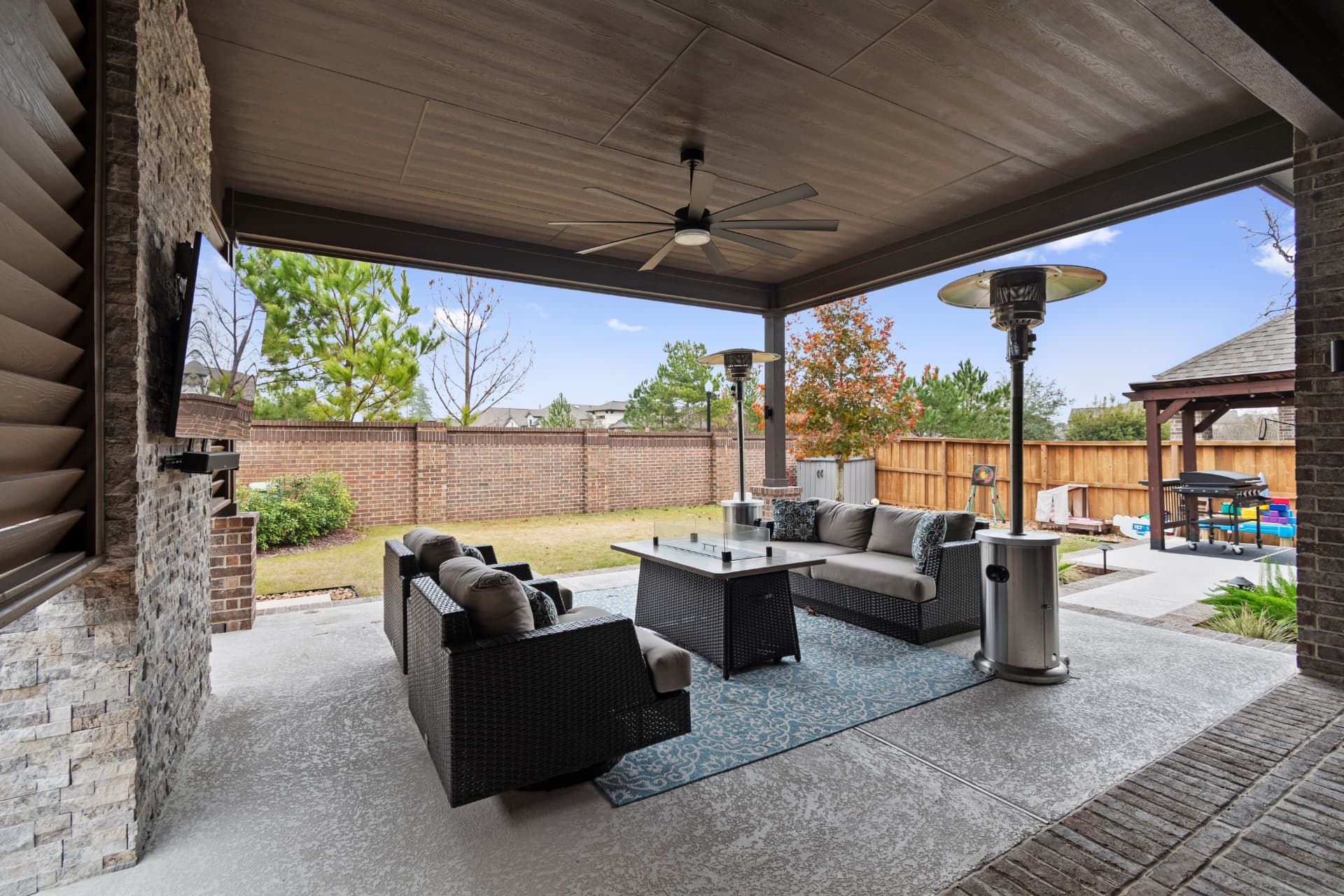 Wide covered patio with fire table, sectional and patio heaters
