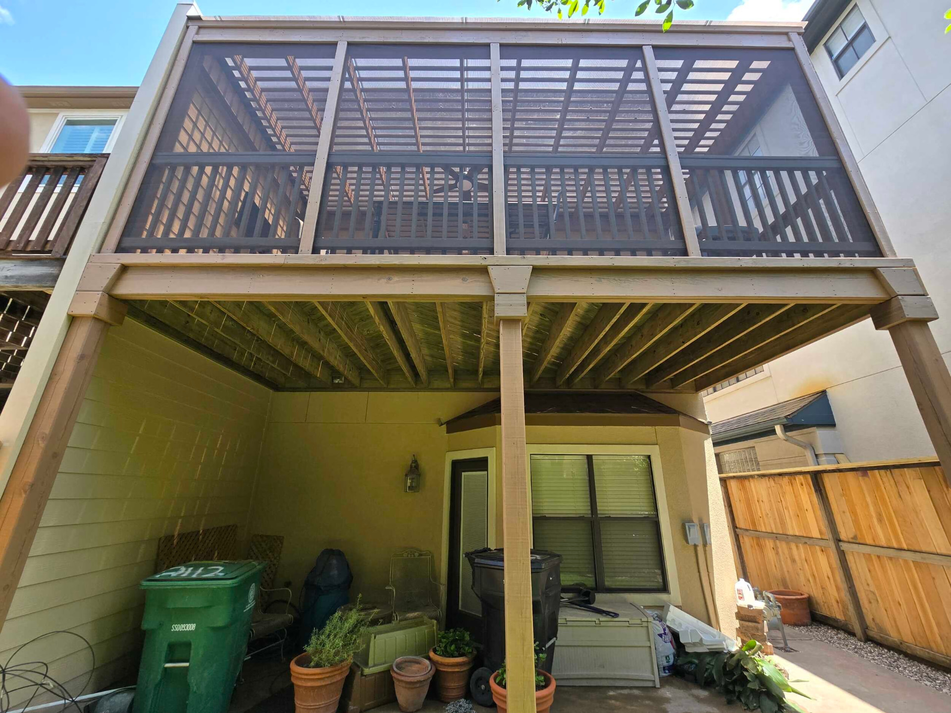Elevated screened deck with pergola-style roof over a covered patio