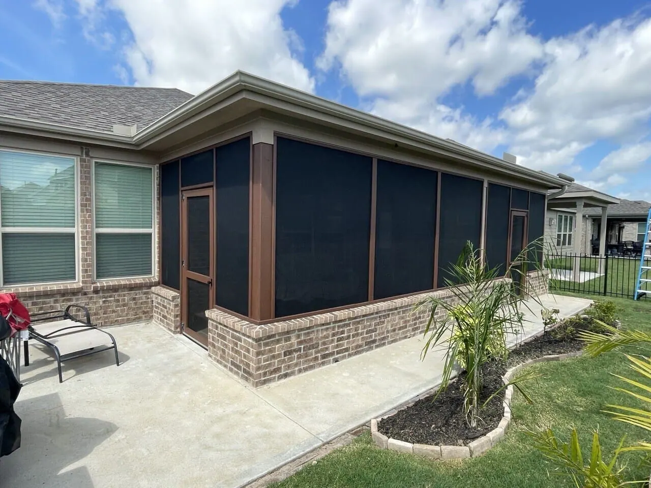 Screened porch with dark bronze framing and brick knee walls