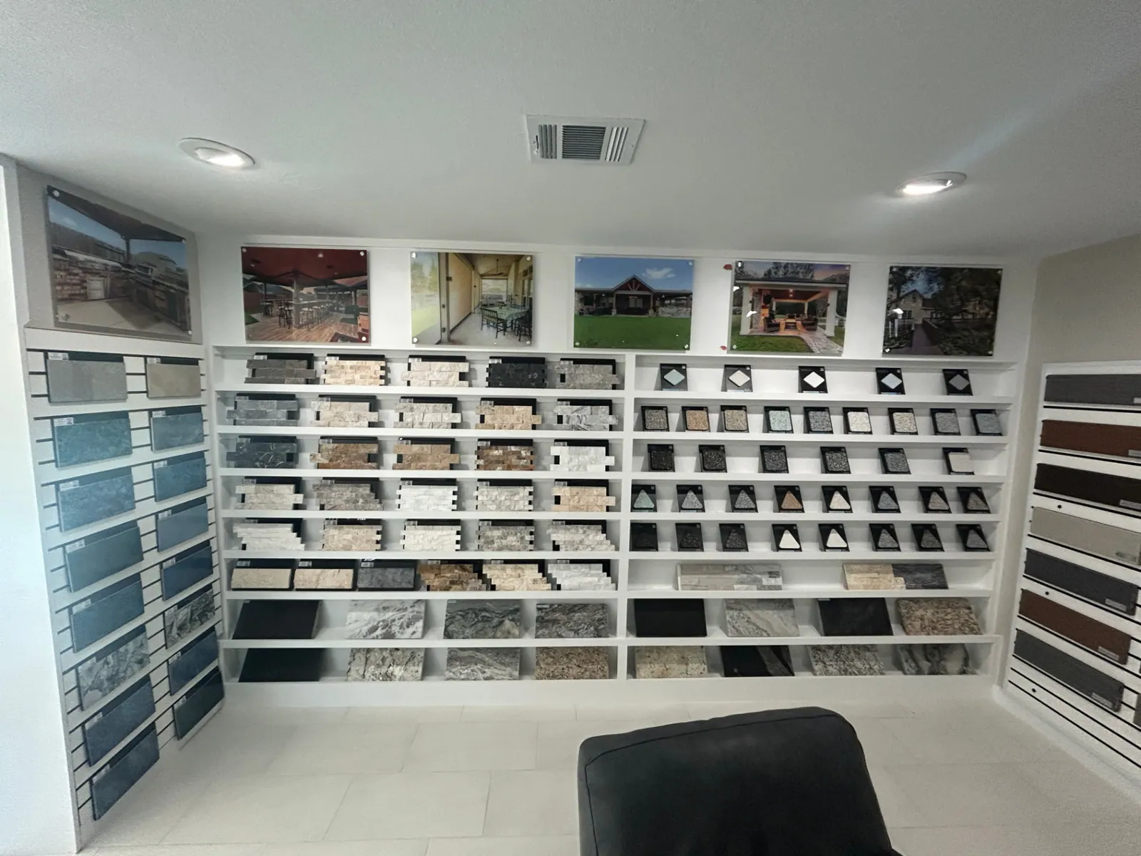 Ledger stone, travertine, and granite countertop samples on display shelving