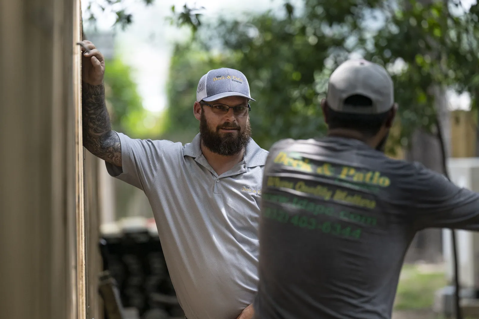 Deck & Patio Company project manager consulting with a team member on site