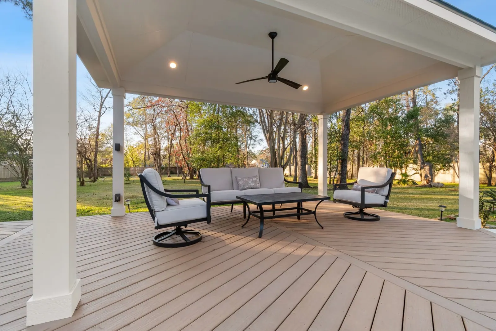 Covered composite deck with vaulted white ceiling, ceiling fan and lounge seating