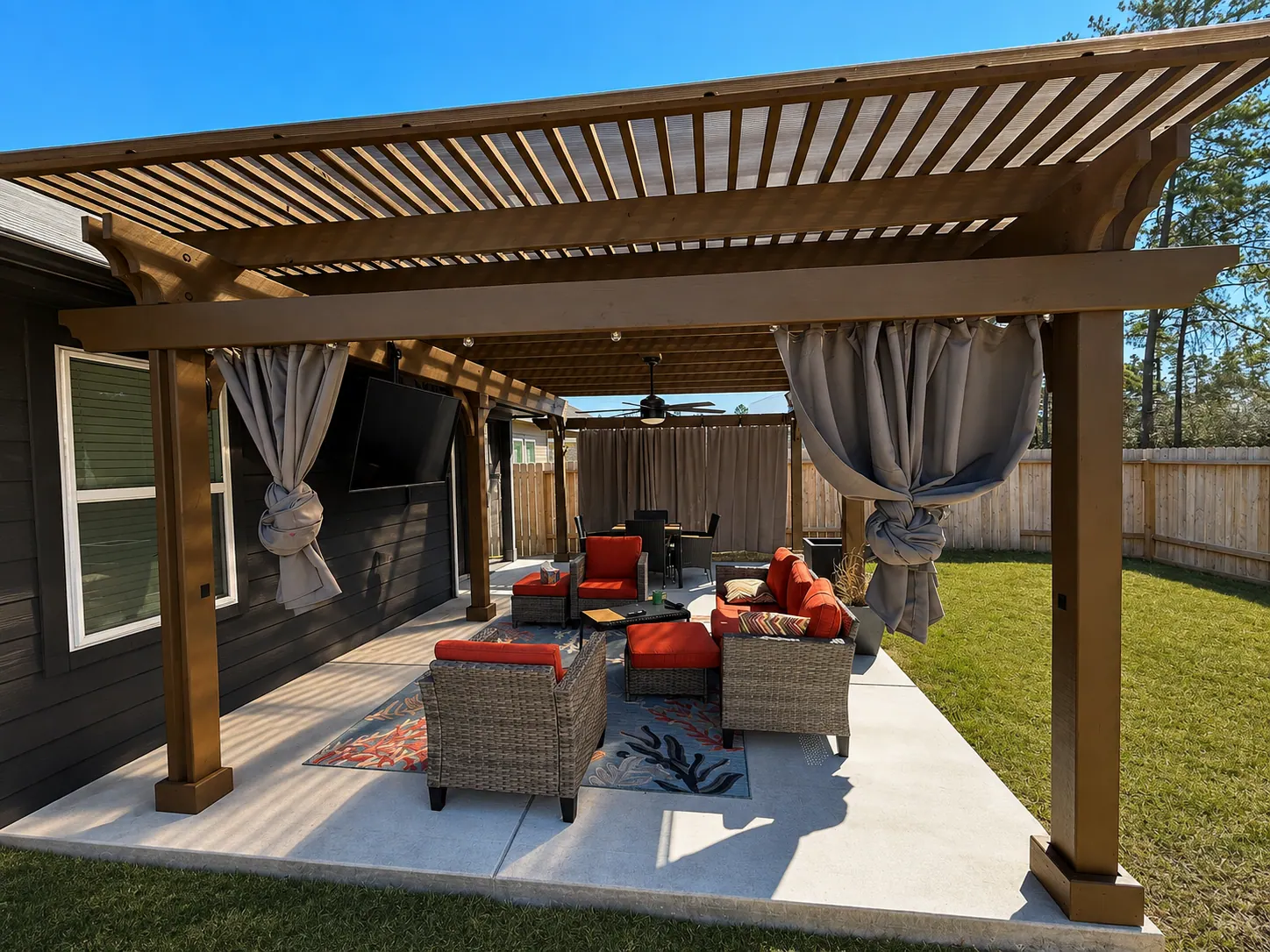Wooden pergola with slatted roof over concrete patio with outdoor seating and curtains