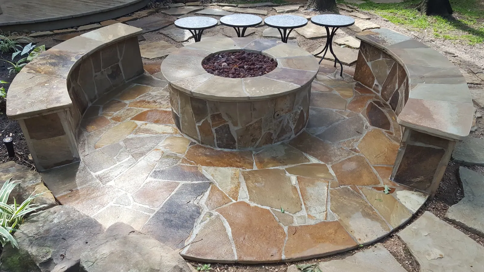 Flagstone fire pit with curved stone seating walls and lava rock
