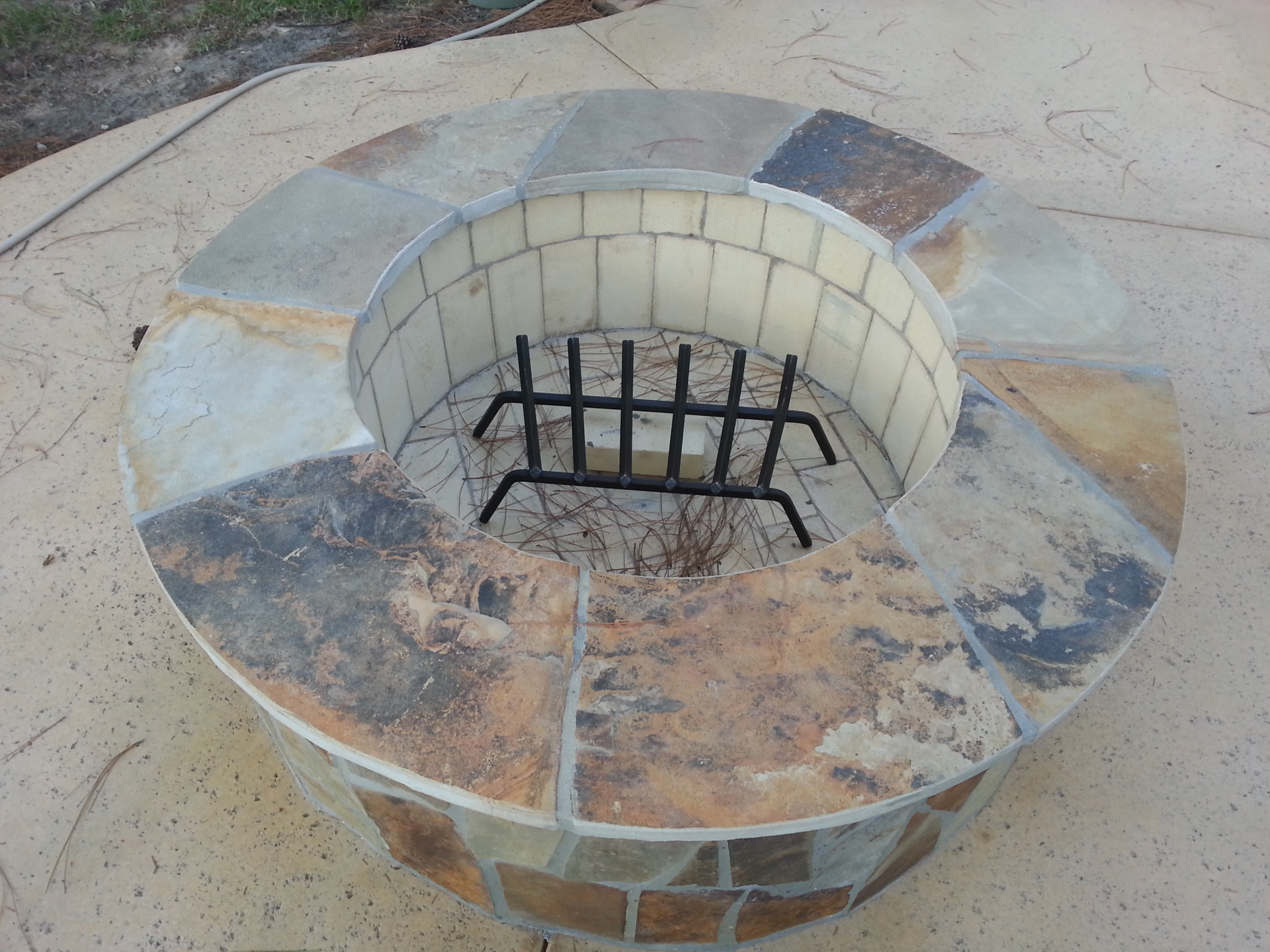 Round flagstone wood-burning fire pit with firebrick interior