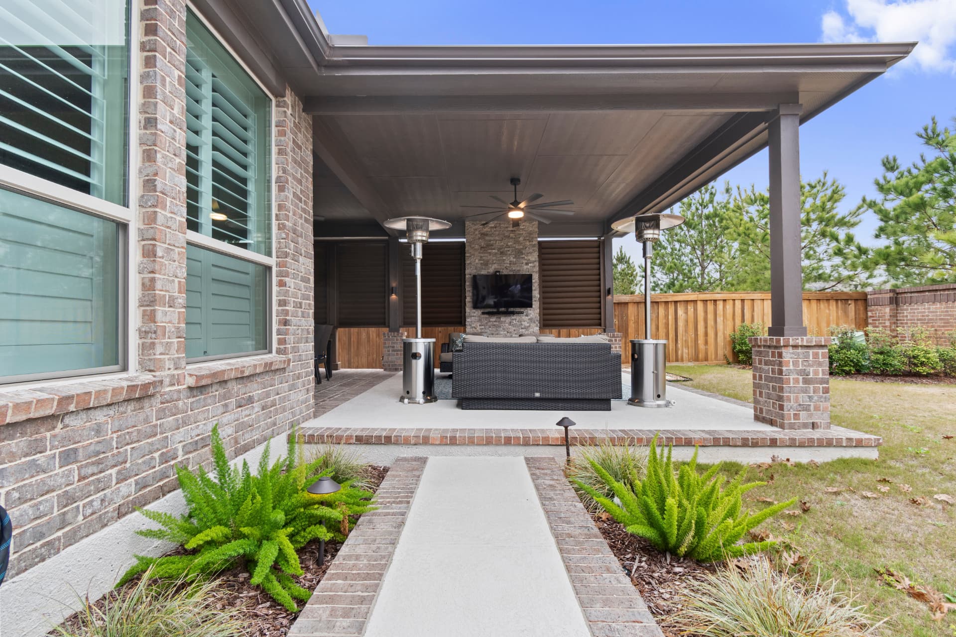 Exterior view of attached patio cover with brick columns and landscaped walkway