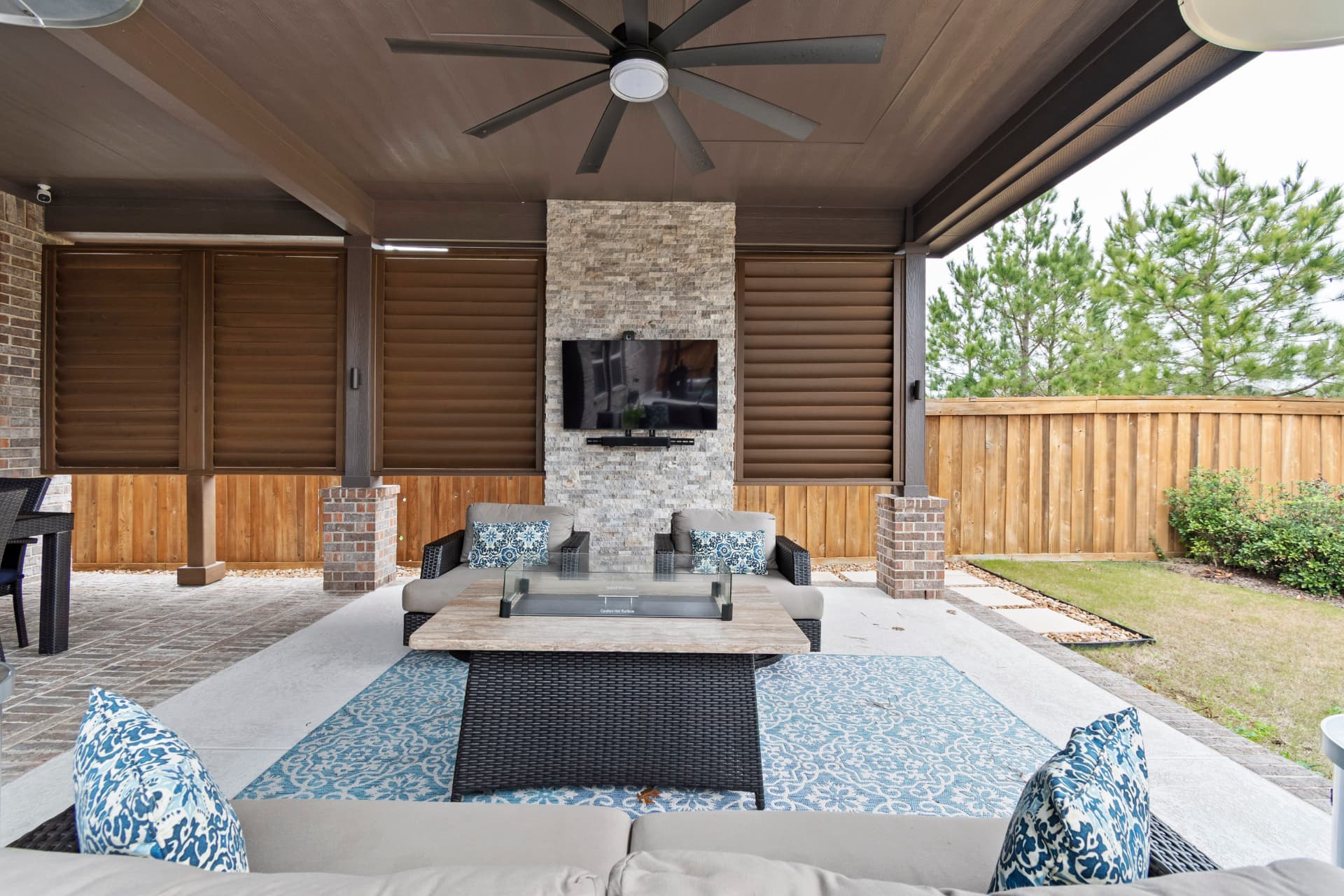 Covered patio lounge with TV on stacked-stone accent wall