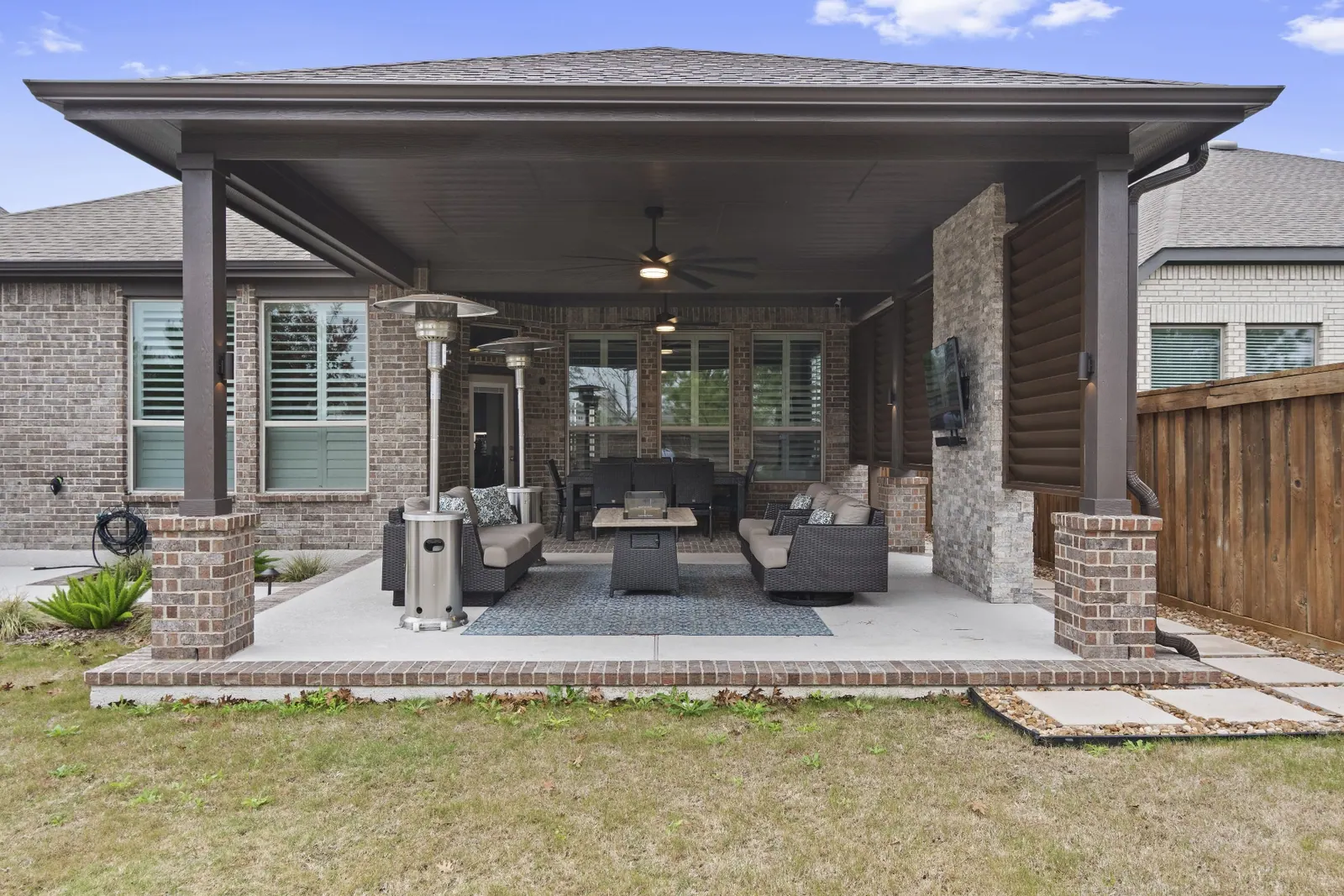 Modern covered patio with brick columns and stone accents