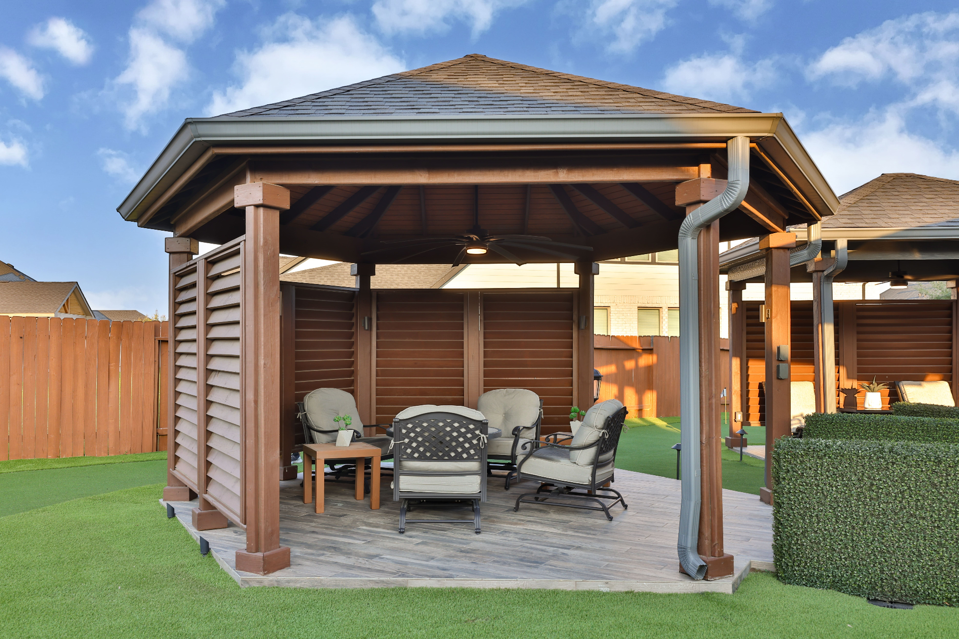 Wood gazebo with louvered privacy walls and ceiling fan