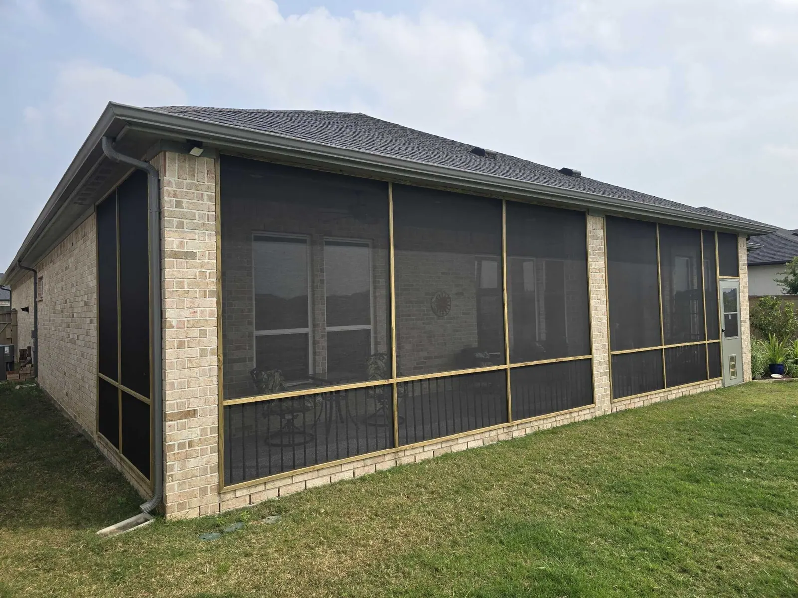 Rear elevation of home with fully screened-in porch enclosure