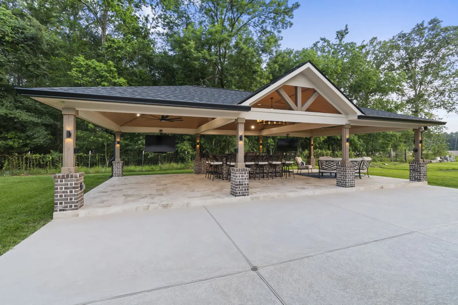 Large freestanding pavilion with mixed gable and hip roof, brick columns and bar seating