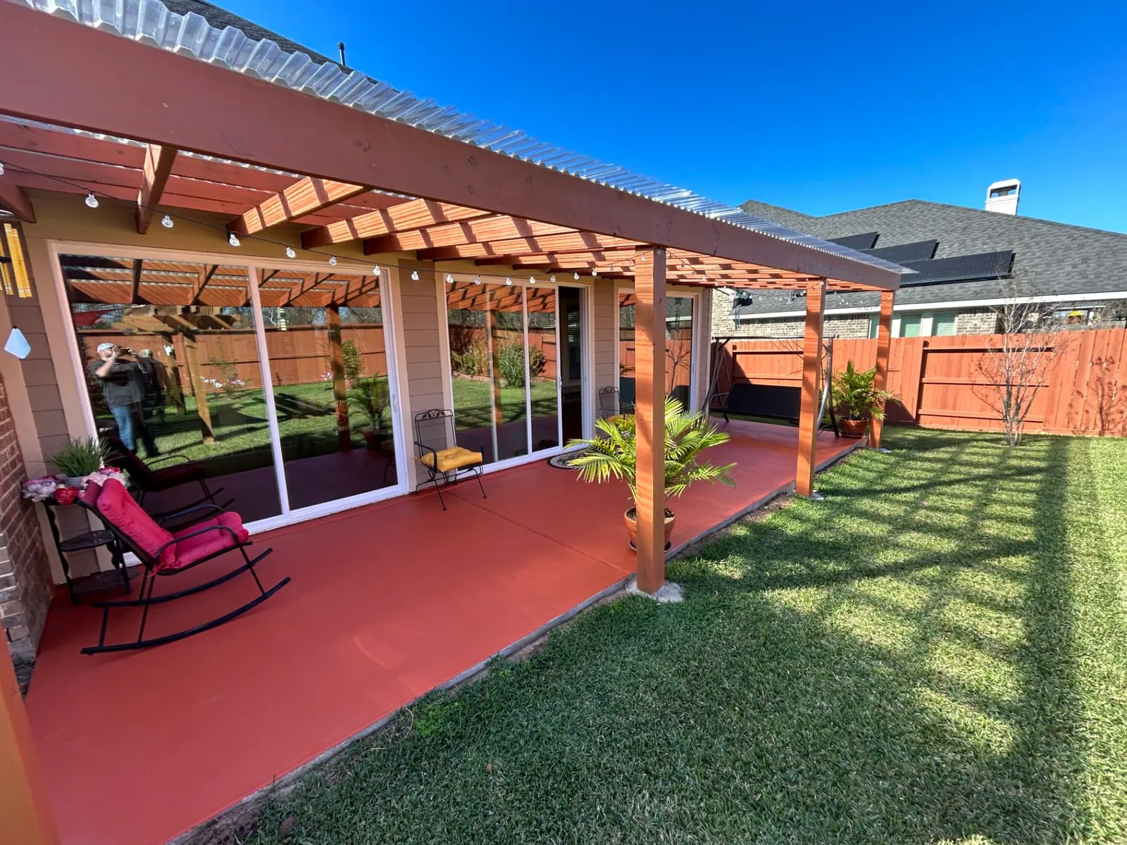 Pergola with polycarbonate panel roof over stained concrete patio